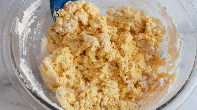stirring dry cornbread batter in bowl