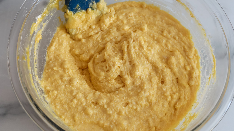 stirring wet cornbread batter in bowl