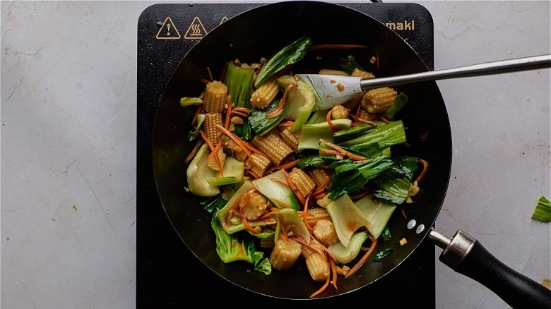 stir frying veggies in pan