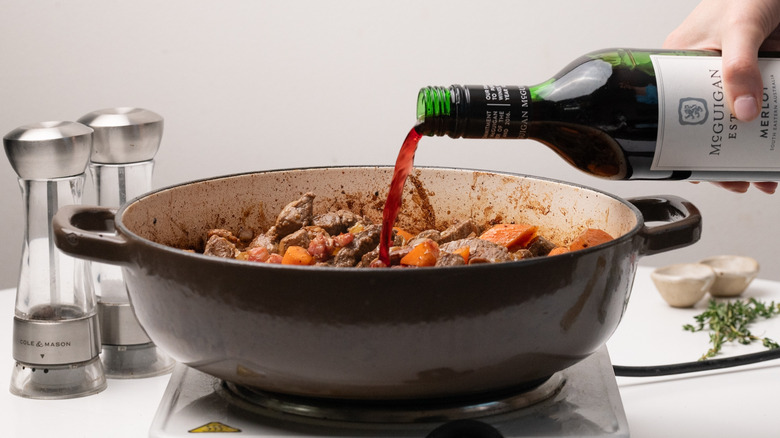 pouring red wine into pan