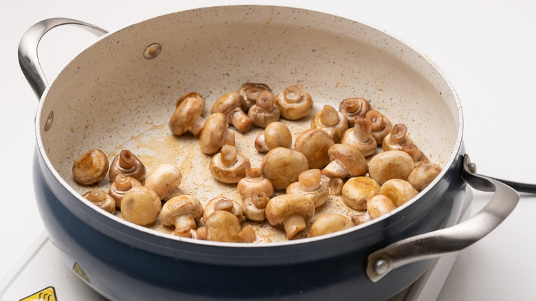 frying button mushrooms in pan