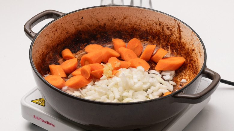 sauteing onion, garlic, and carrots in pan