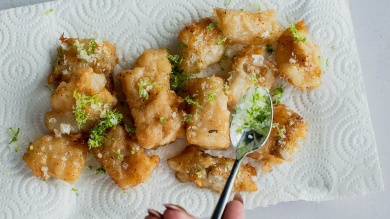 adding lime to fried fish