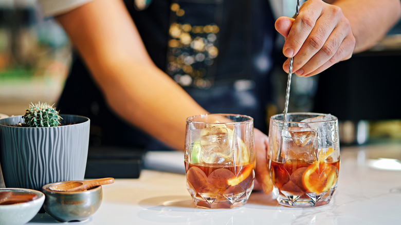 Bartender mixing two cocktails