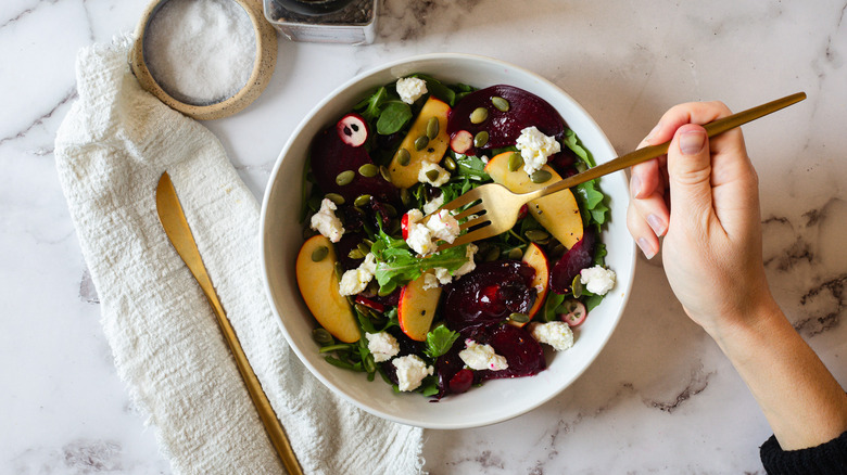 overhead view of salad with cutlery and salt