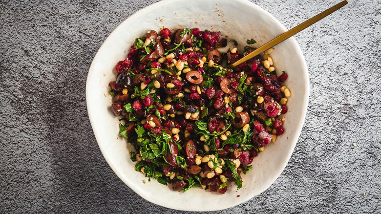 pomegranate relish with spoon in white bowl