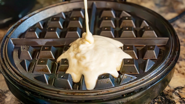 batter pouring into waffle iron