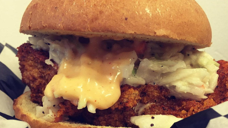 fried chicken with coleslaw and cheese on bun