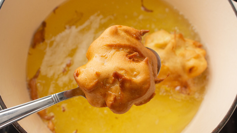 fried apple fritter in spoon