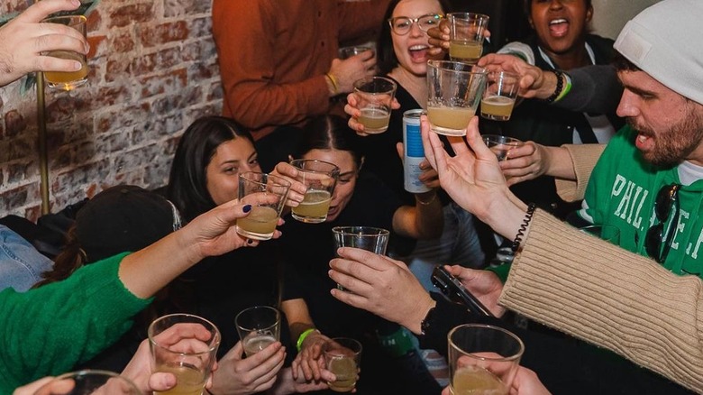 people holding up drinks