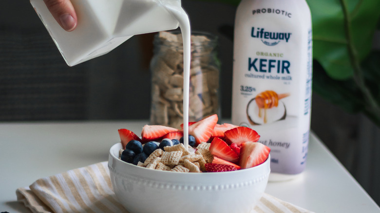 lifeway kefir being poured into a bowl of cereal and fruit