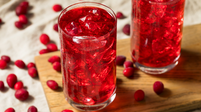 Glasses of iced cranberry juice on cutting board