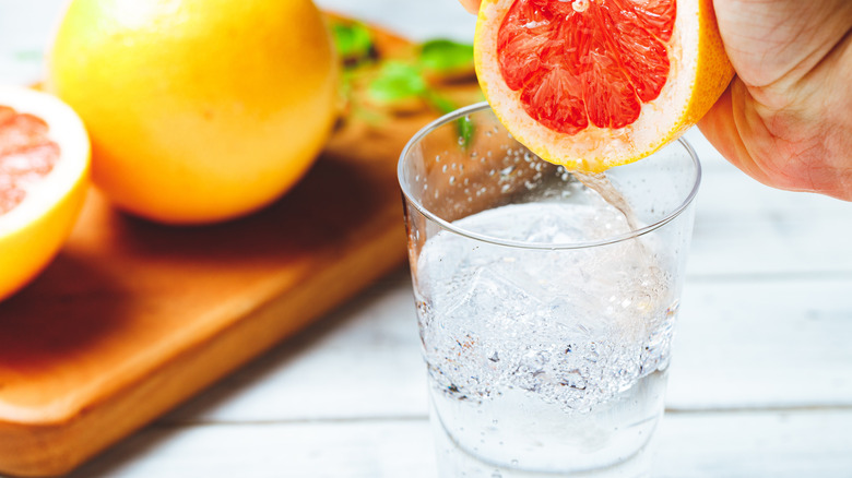 Grapefruit being squeezed into soda