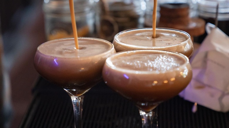 Espresso martinis being poured into coupes