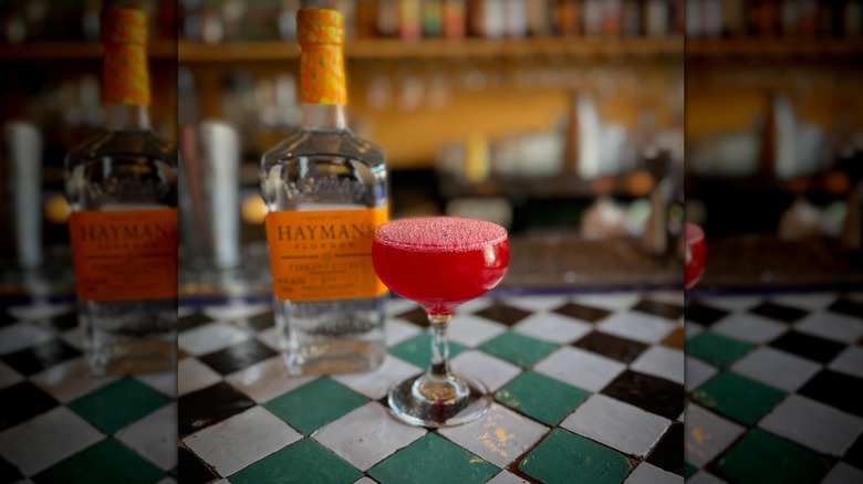 Red cocktail with glass bottle