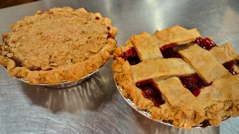 Two cherry pies on table