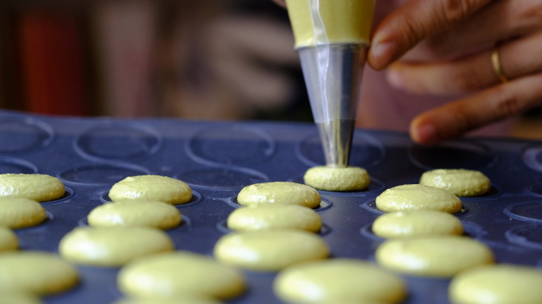 piping out macarons