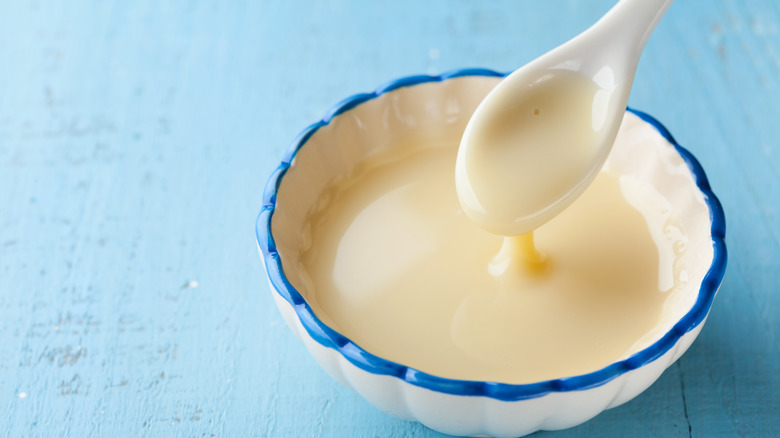 Evaporated milk in a white dish with spoon