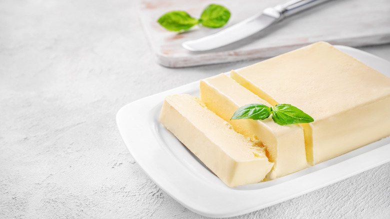 Block of fresh butter on white ceramic dish