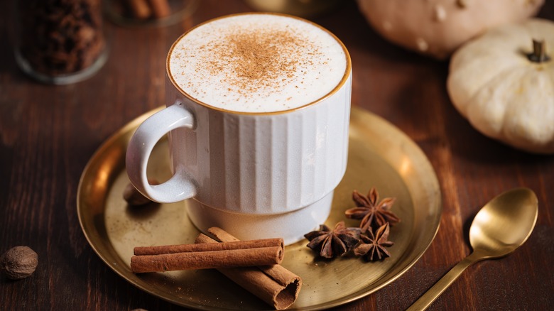 cup of coffee with whole cinnamon, nutmeg, and star anise