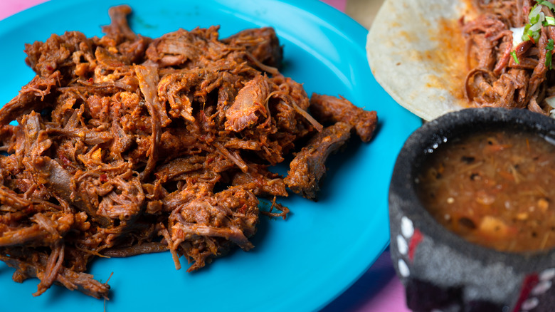 shredded beef barbacoa on bright blue plate