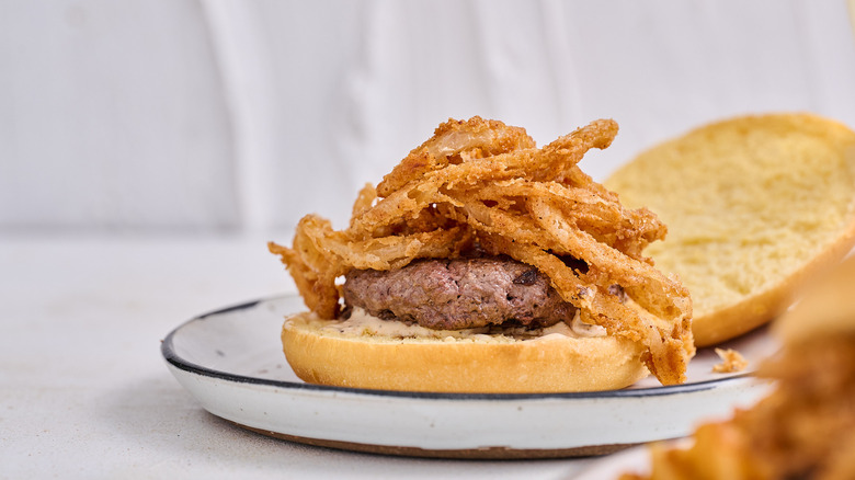 bison burger with onion straws on table