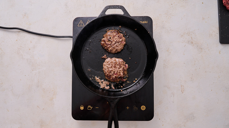 cooking burgers in skillet