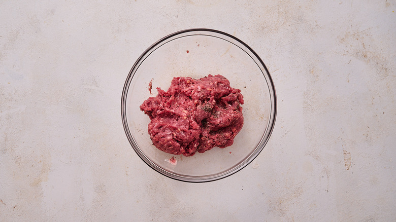 mixing burger meat in bowl