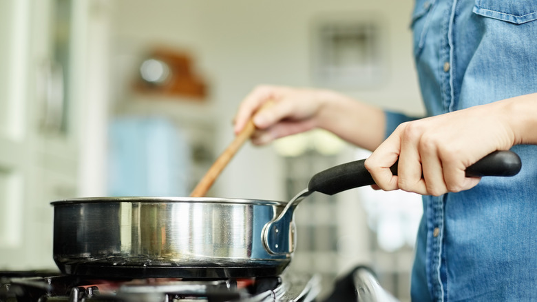 woman stirring pot on stove