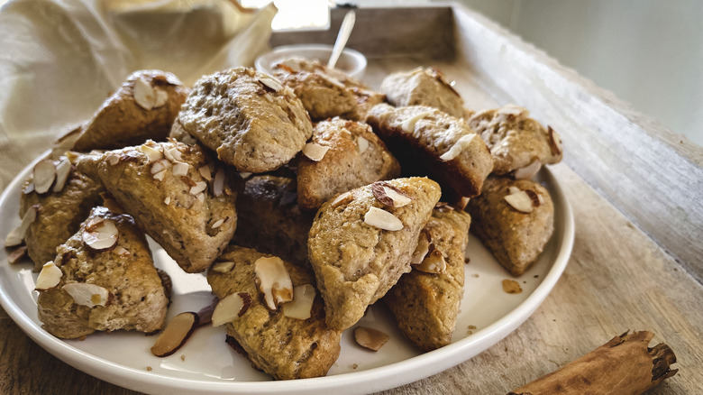 triangular scones with almonds on white plate