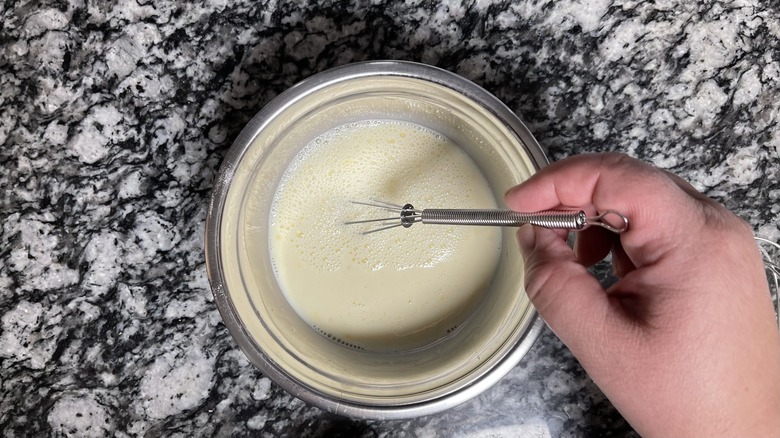 hand whisking bowl of wet ingredients