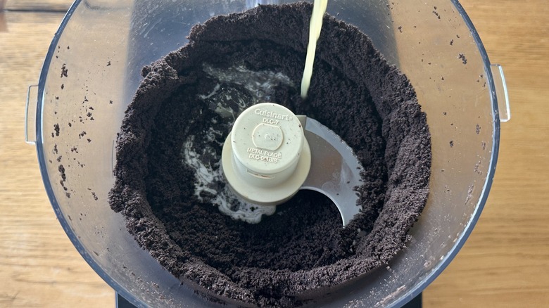 Pouring butter into Oreo crumbs