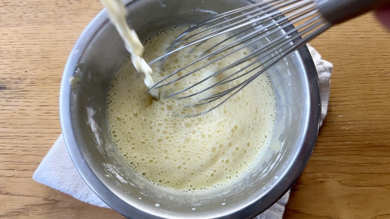 Whisking hot liquid into egg yolks