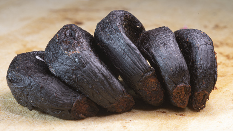 Black garlic cloves on surface