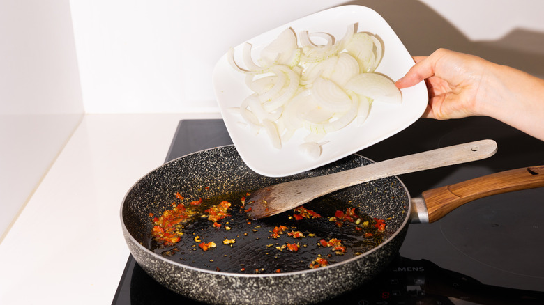 adding onions to hot skillet 