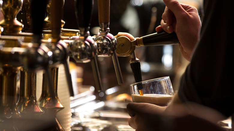 Bartender pouring stout into glass