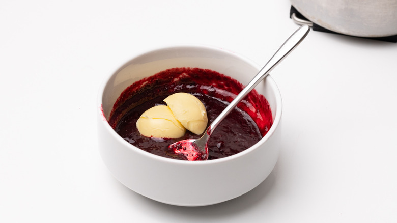 stirring butter into blackberry glaze