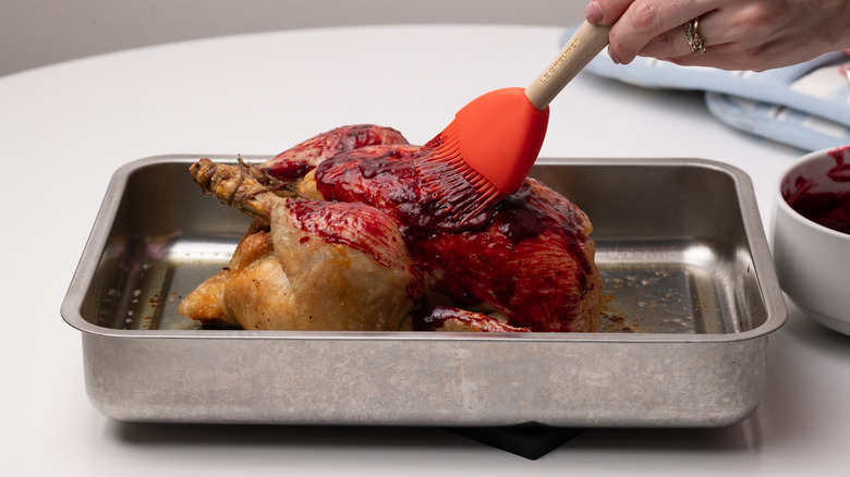 brushing chicken with blackberry glaze