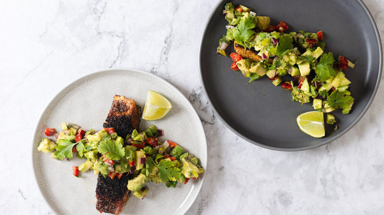 two portions of fish topped with salsa