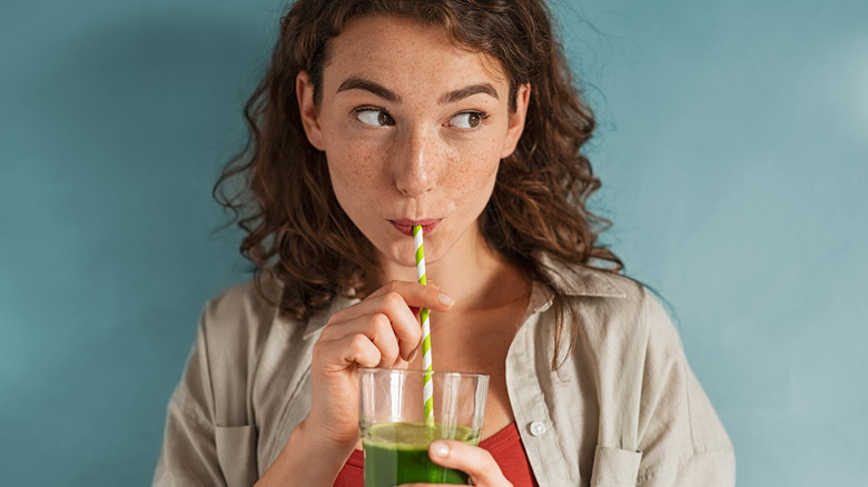 Woman drinking smoothie with straw