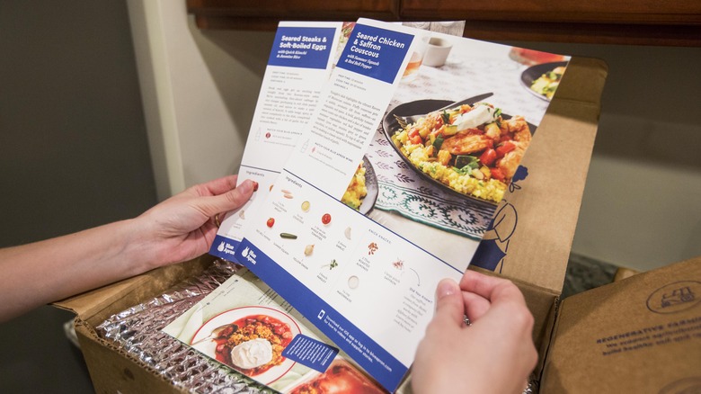 person holding Blue Apron recipes