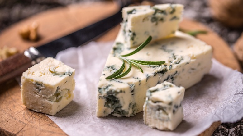 Blue cheese wedge and cubes on a cutting board 