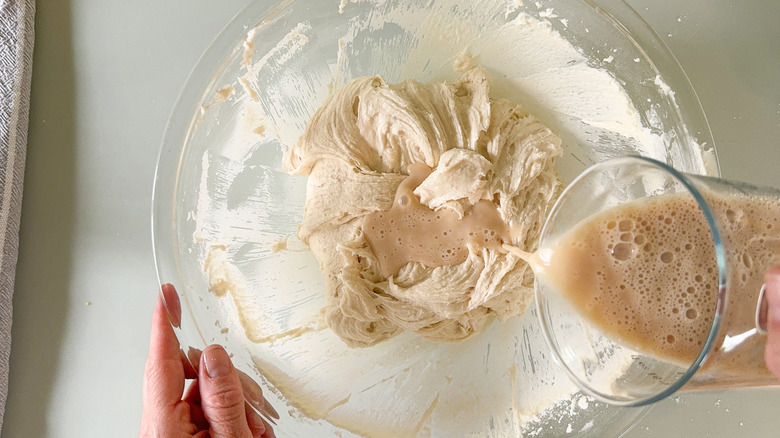 Adding egg whites and milk to cake batter in mixer bowl