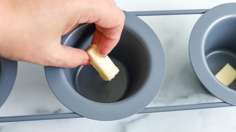 adding butter cubes to pan