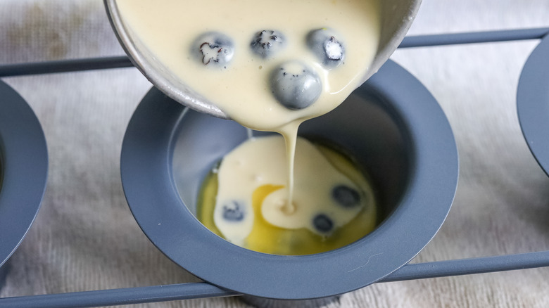 pouring blueberry batter into pan