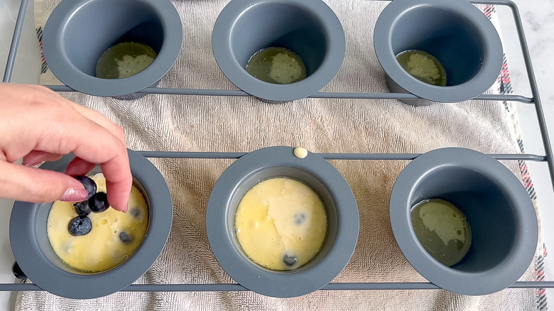 sprinkling blueberries in popover pan