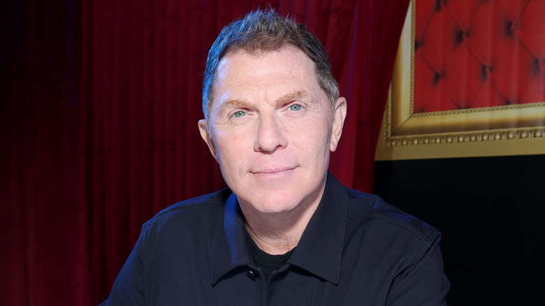 bobby flay seated at a table