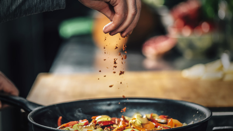 Sprinkling paprika on vegetables