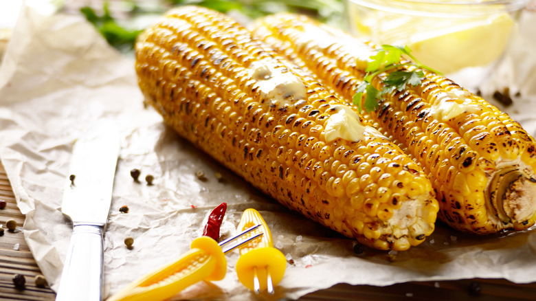 grilled corn on paper with knife