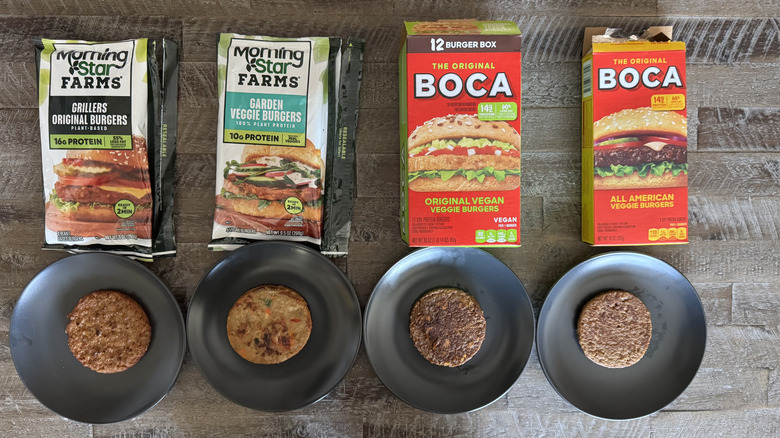 veggie burgers on plates on wooden table next to various product boxes